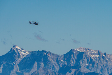 Helicopter soaring above the majestic Bavarian Allgau Alps on a crisp autumn day