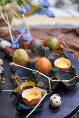 colored dark pallet with eggs for Easter stands on a black board on a table, top view