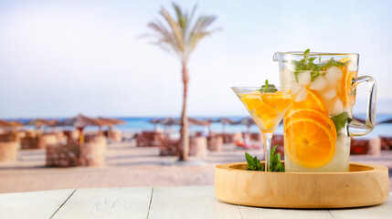 Cold cocktail with oranges fruit on the exotic beach