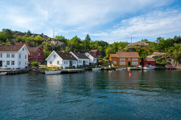 picturesque waterfront village with boats and lush greenery.