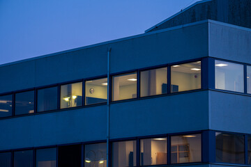 office building at dusk with lit windows.