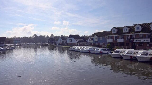View down the River Bure as seen from the bridge in Wroxham, a small but popular tourist destination.  Captured on a bright and sunny morning in the springtime