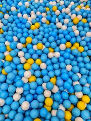 Ball Pit Filled with Blue, White, and Yellow Colorful Plastic Balls