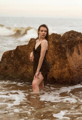 Slender girl in the sea among the waves