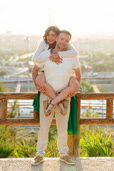 Young man giving piggyback ride to his girlfriend in a park