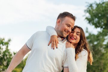 Obraz premium Happy couple embracing and smiling in a park