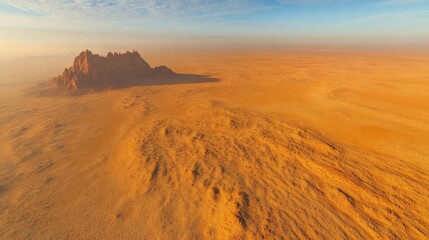 Expansive aerial view of arid landscape with rocky formation under blue sky