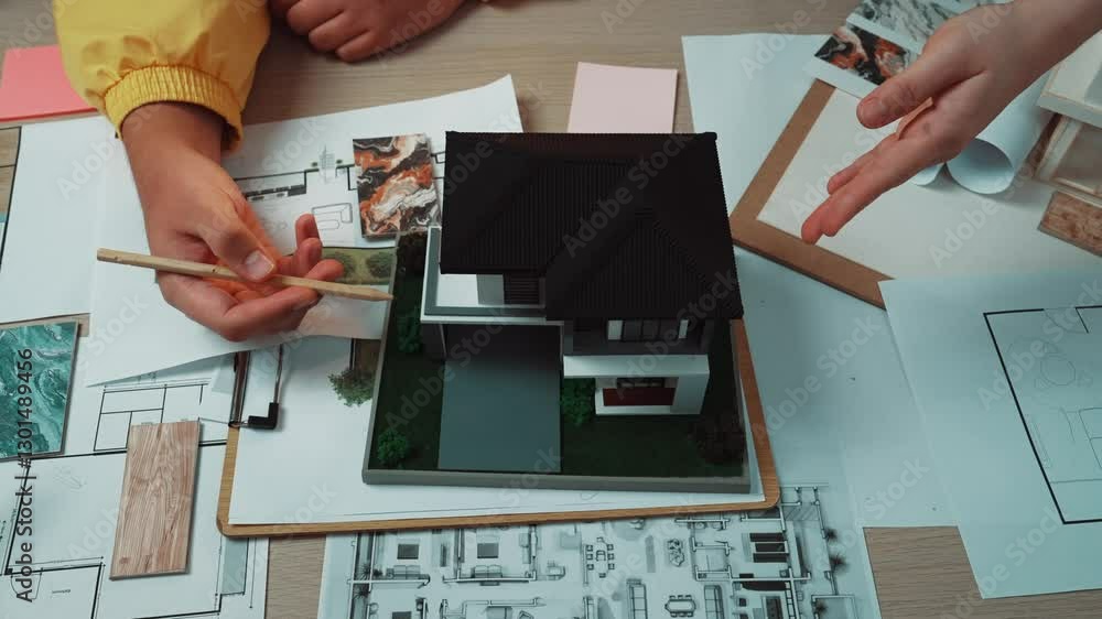 Poster two architects collaborate on a detailed home design project, engaging with models and sketches on a