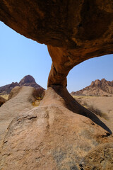 Inside the Spitzkoppe arch, revealing stunning granite landscapes of Damaraland with Spitzkoppe in the background.