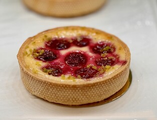 Enjoy a raspberry tart with a crunchy pistachio crust, the perfect treat for dessert lovers everywhere