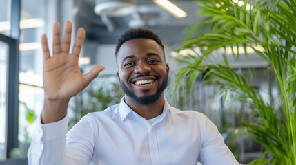 Fototapeta premium A smiling professional man in an office waving at his smartphone camera during a virtual meeting, engaging in remote business communication with confidence.virtual business call, p