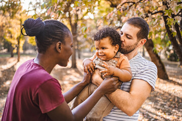 Boy in the arms of his parents in the park