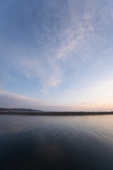 Fototapeta premium 北海道の網走の道の駅の裏の港のフェリーや漁船と朝焼けの空と朝日