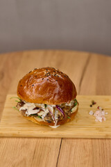 Close-up of hamburger on wooden board with knife