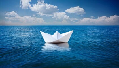 Obraz premium white paper boat floating in blue sea