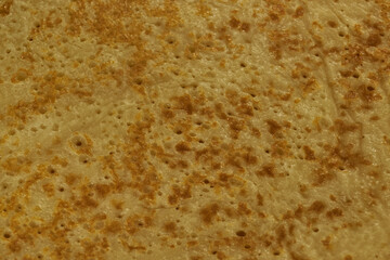 Homemade pancakes for celebrating Pancake day. Thin, ruddy pancakes on Shrovetide with a golden crust and holes. Close-up.