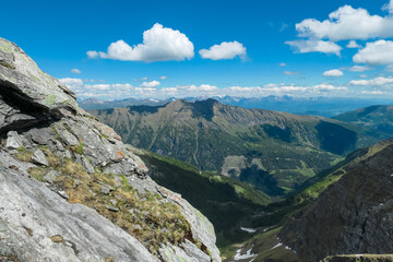 Rugged rocky frames sweeping view of Reitereck mountain peak in Ankogel Group, Lieser-Maltatal Valley, Carinthia, Austria. Verdant slopes. Distant alpine ranges in remote wilderness of Austrian Alps