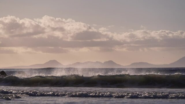 Waves in False Bay at Pringle Bay village glow in the golden sunset light, creating a serene and picturesque coastal scene