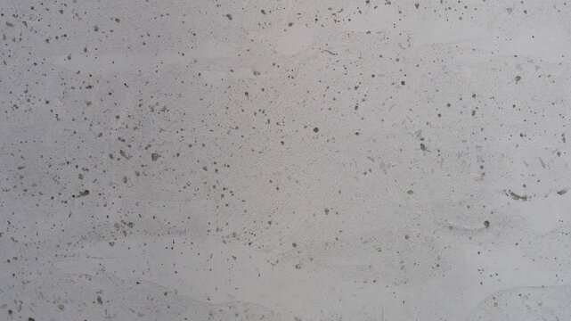 Close-up of a raw concrete wall with a textured surface and imperfections