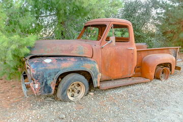Forest Relic Old Car rusting away in the Forest on gravel