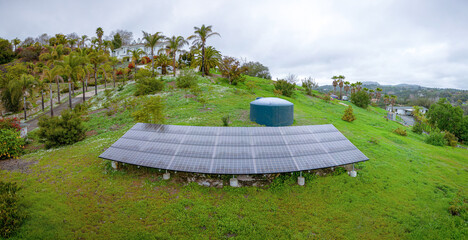 Fallbrook, California- Panorama of solar panels and cistern watertank on a sloped farm