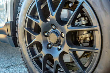 Close up of offroading tires with black spokes and break pads showing between the spokes