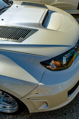 Car hood with vent for airflow on a white upgraded vehicle