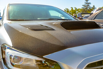 Carbon fiber hood on a white car