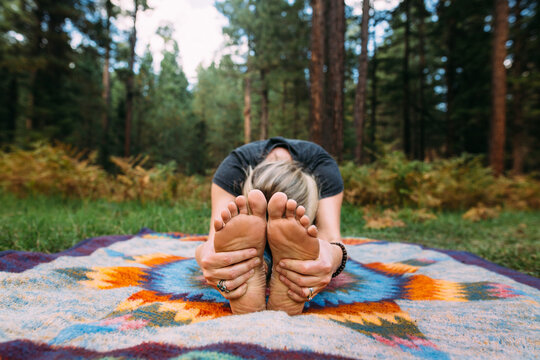 young woman doing yoga in the forest 