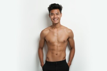 Fototapeta premium Half-Length (Waist-Up) portrait of young stylish smiling Burmese male model in sexy wear isolated on pure white background looking at camera