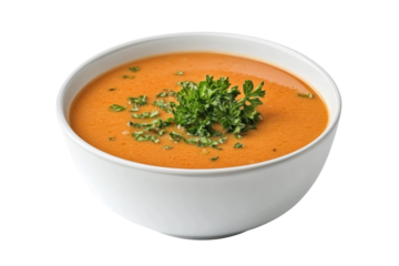 Creamy orange soup garnished with fresh herbs, cut out