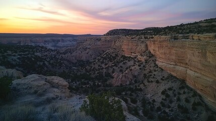 Fototapeta premium Sunset over a canyon with desert landscape.
