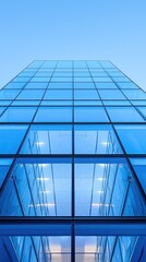 Modern glass skyscraper facade with blue sky background