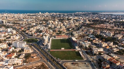 Obraz premium Aerial view of a coastal cityscape with a football stadium in Larnaca, Cyprus.