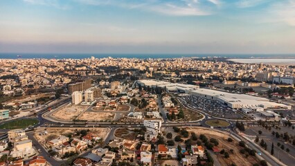 Aerial view of Larnaca cityscape with sprawling urban architecture and the Mediterranean Sea.