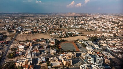 Aerial view of a sprawling residential area with scattered buildings and open fields.