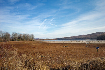 Drying lakebed on a late winter afternoon. Droughts are a period of abnormally dry weather sufficiently prolonged for the lack of water to cause serious hydrologic imbalance in the affected area.