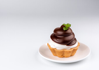 chocolate cake (minitart) with cream on light background