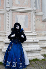 Naklejka premium Venice, Italy - People dressed in carnival masks are photographed by tourists in the scenery of the ancient Venetian palaces