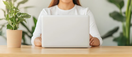 Woman using laptop computer at home office desk working remotely home workspace