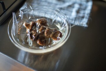 ラップをかけて干し椎茸を水で戻しているところ