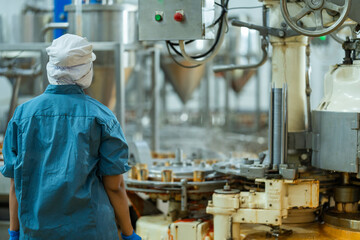 Inspector checking automated machinery in food production facility Focus on quality control safety...