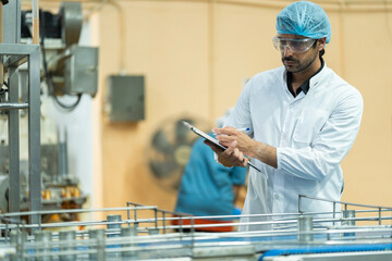 Industrial technician conducting quality checks on canned food in a manufacturing facility Emphasis...