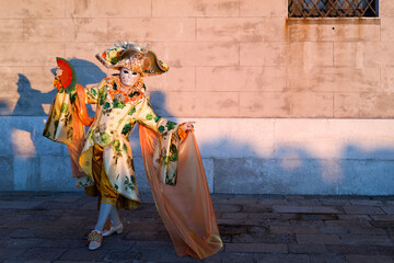 Venice, Italy - People dressed in carnival masks are photographed by tourists in the scenery of the ancient Venetian palaces