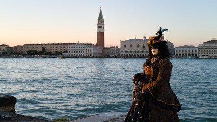 Venice, Italy - People dressed in carnival masks are photographed by tourists in the scenery of the ancient Venetian palaces