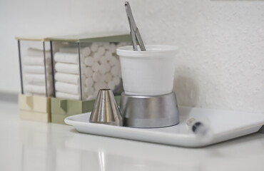 In the dentist's office there is a  Organized Dental Workspace with Tools and Cotton Rolls
