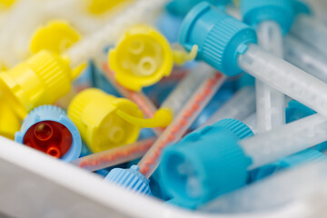 Colorful Medical Syringes and Caps in Container