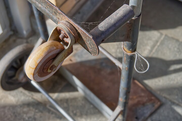 Close-Up of a Rusty Metal Cart with Worn Wheel