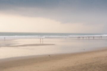 Blurry background of people at beach with cloudy at sunset