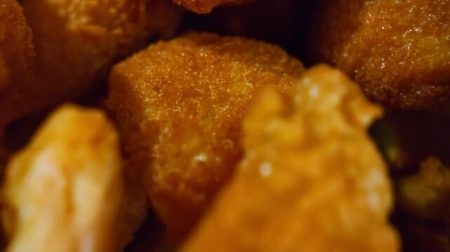 Closeup of fried chicken nuggets or broast falling on camera